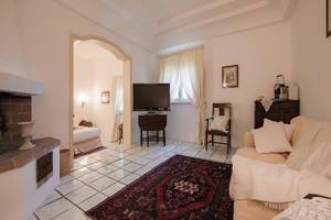 Il Melograno Hotel Wohnzimmer mit Couch, Fernseher, Kamin und Tisch