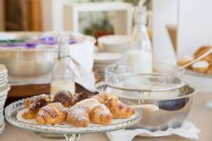 Frühstücksbuffet im Hotel Il Melograno mit Croissants, Milch und Kaffee