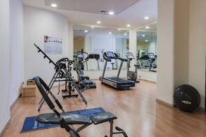 Fitnesscenter im Hotel Il Melograno mit verschiedenen Trainingsgeräten und einem großen Fitnessball.