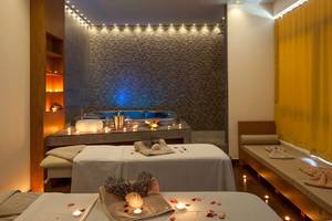 Behandlungsraum im Blue Lagoon Resort mit zwei Massagetischen, Kerzen und einem Whirlpool.
