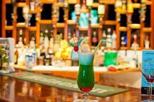 Cocktail Bar im Fihalhohi Island Resort mit grünem Cocktail und grünem Strohhalm.