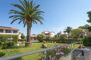 Außenansicht des Acharavi Beach Hotels mit Terrasse, Blumen und Palmen