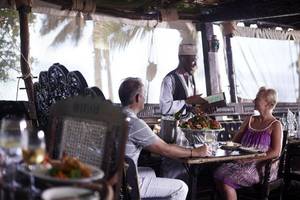 Gäste der Severin Sea Lodge sitzen bei einem Essen an einem Tisch im Freien.