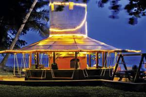 Severin Sea Lodge mit beleuchteter Bar und Sitzgelegenheiten im Freien bei Sonnenuntergang.