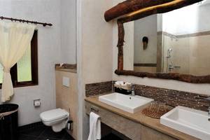 Badezimmer der Severin Sea Lodge mit zwei Waschbecken, Spiegel und Toilette.