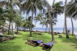 Außenbereich des Severin Sea Lodge Hotels mit Strand, Liegestühlen und Palmen