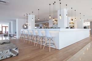 Innenbereich der Bar im HM Gran Fiesta Hotel mit weißen Stühlen und Theke.