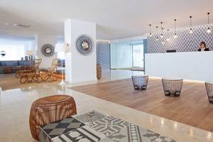 Lobby des HM Gran Fiesta Hotels mit Rezeption, Sitzmöbeln und blau-weißem Wandmuster.