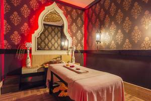 Spa-Behandlungsraum in der Villa Side Residence mit rotem Wanddesign und orientalischen Mustern.