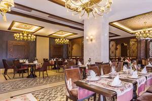 Innenbereich des Restaurants der Villa Side Residence mit reich verzierten Decken und eleganten Tischdekorationen.