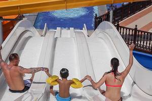 Familie auf der Wasserrutsche im Wasserpark der Villa Side Residence