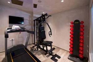 Fitnessraum im Hotel Cactus Mare mit Laufband, Krafttrainingsgeraet und Hanteln.
