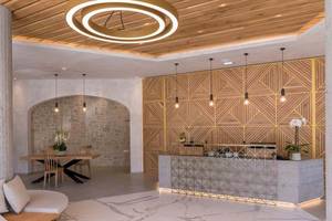 Innenansicht der Rezeption des Cactus Mare Hotels mit Marmorboden, Holzdecke und architektonischen Details.