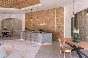 Innenansicht der Lobby im Cactus Mare Hotel mit Marmorboden, Holzdecken und modernen Möbeln.