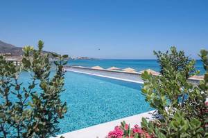 Außenansicht des Pools im Cactus Mare Hotel mit Blick auf das Meer und umliegenden Pflanzen.