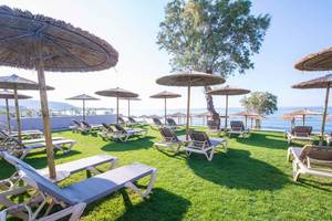 Strandliegen und Sonnenschirme vor dem Cactus Mare Hotel am Meer