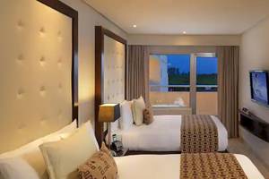 Hotelzimmer im Paradisus Playa del Carmen mit zwei Betten, Fernseher und Balkon.