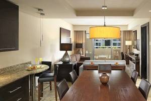 Innenansicht einer Suite im Paradisus Playa del Carmen mit Esstisch, Sofa und moderner Dekoration.