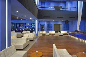 Lobby des Melia Marina Varadero Hotels mit weißen Sofas, blauen Wänden und einer Bar.
