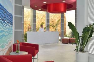Empfangsbereich des Melia Marina Varadero Hotels mit roter Decke und Rezeptionstisch.