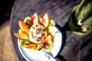 Obstsalat mit Sahne und Nüssen auf dem Tisch im Hotel Plaza Beach