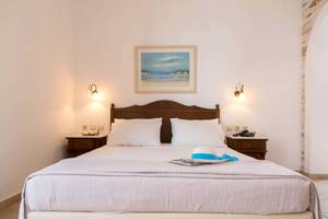 Schlafzimmer im Plaza Beach Hotel mit Bett, Nachttischen und Gemälde an der Wand.