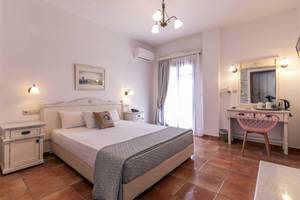 Schlafzimmer im Plaza Beach Hotel mit Bett, Nachttischen und Klimaanlage