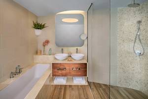 Das Badezimmer im Retreat Palm Dubai MGallery by Sofitel mit Badewanne, zwei Waschbecken und Dusche.