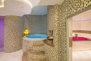 Jacuzzi-Raum im The Retreat Palm Dubai MGallery by Sofitel mit gefliesten Wänden und marmorner Treppe.