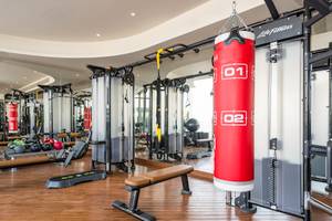 Fitnessstudio im Retreat Palm Dubai MGallery by Sofitel mit roten Boxsäcken und Trainingsgeräten