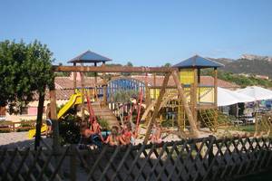 Spielplatz im Baia Caddinas Hotel mit Rutschen und Schaukeln im Freien