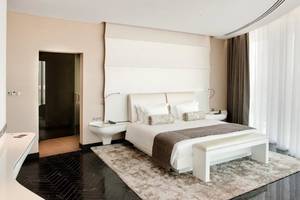 Schlafzimmer im W Abu Dhabi - Yas Island mit einem weißen Bett, Nachttischen und einem weißen Teppich.