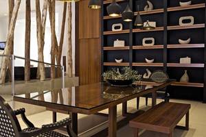 Essbereich im Napa Mermaid Hotel & Suites mit runden Tisch, Holzbank und Regalwand.