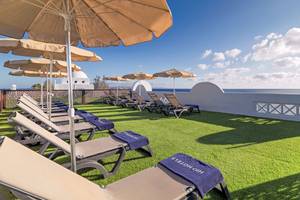 Dachterrasse des H10 Timanfaya Palace mit Sonnenliegen, Überdachungen und Meerblick