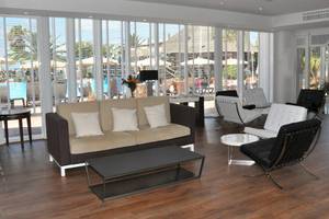 Lobby des H10 Timanfaya Palace mit Sofas, Tischen und Blick auf den Pool.