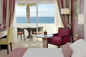 Zimmer im H10 Timanfaya Palace Hotel mit Blick auf das Meer und eine Terrasse.