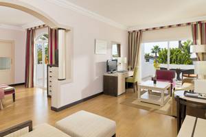 Innenansicht einer Suite im H10 Timanfaya Palace mit Wohnzimmer, Schlafzimmer und Schreibtisch.