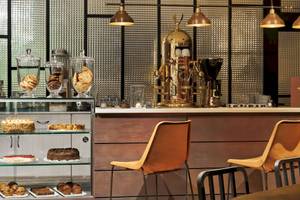 Innencafe des H10 Timanfaya Palace Hotels mit Kuchen, Cookies und Kaffeemaschine.