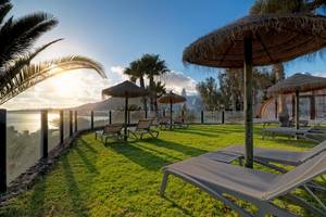 Terrasse des H10 Timanfaya Palace mit Liegen und Sonnenschirmen am Meer