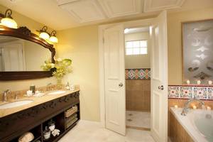Badezimmer im Sandals Whitehouse European Village & Spa mit zwei Waschbecken, Badewanne und Dusche.