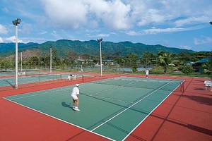 Tennisplatz im Barcelo Tambor Hotel mit Spielern und einer bergigen Landschaft im Hintergrund.