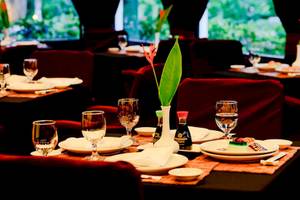 Restauranttisch im Barcelo Tambor Hotel mit Geschirr, Gläsern und Pflanzendekor.