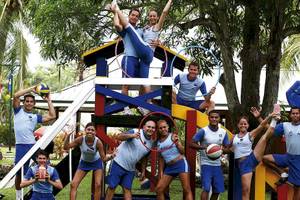 Gruppe junger Athleten des Barcelo Tambor Hotels beim Sport vor einem Spielplatz