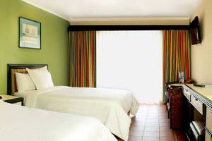Doppelzimmer im Barcelo Tambor Hotel mit zwei Betten und grünen Wänden.