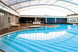 Innenpool im Hotel The Ibiza Twins mit Glasdach und Loungebereich.