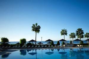 Außenpool des Atlantica Miramare Beach Hotels mit Sonnenliegen und Palmen.