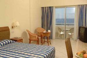 Doppelzimmer im Atlantica Miramare Beach Hotel mit Meerblick, Bett, Tisch, Fernseher und Balkon.