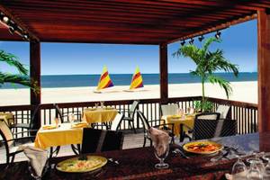 Terrasse des Divi Tamarijn Aruba mit Blick auf das Meer und Segelboote.