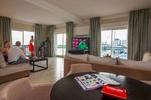 Hotel Wohnzimmer mit Fernseher, Sofas, Tisch und Aussicht auf den Hafen