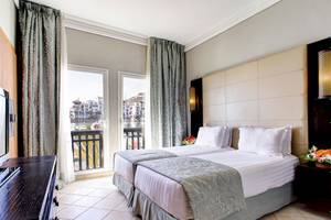 Doppelbettzimmer im Bianca Beach Resort mit Blick auf die Stadt und Balkon.